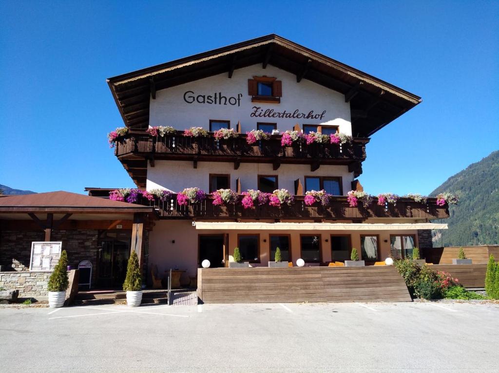 a building with a balcony with flowers on it at Zillertalerhof in Ried im Zillertal