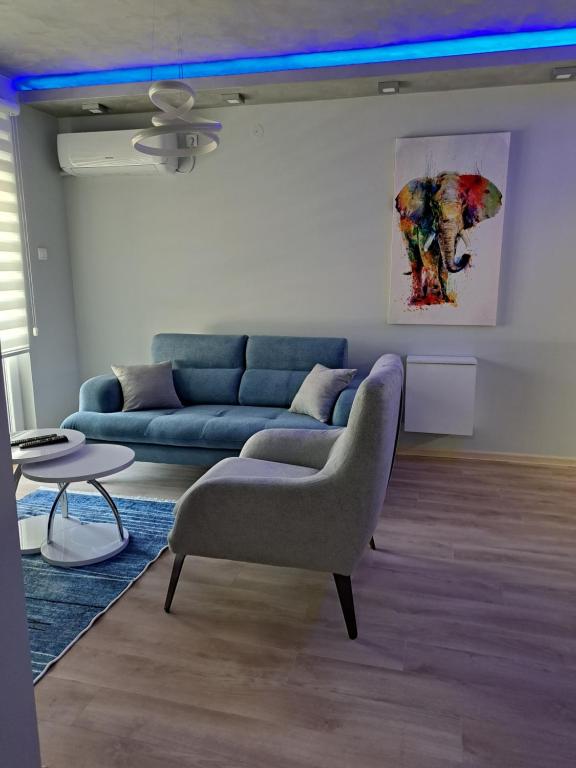 - un salon avec un canapé bleu et une table dans l'établissement Stan na danS Šid, à Šid