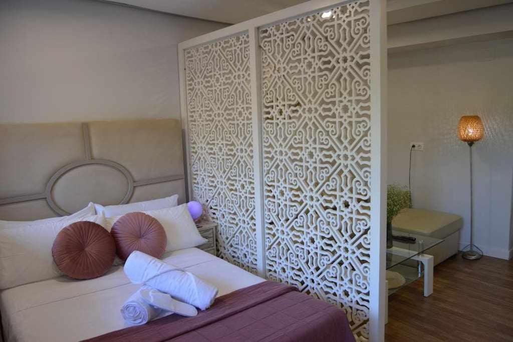1 dormitorio con cama con almohadas y pared en Apartamento Lirio de Agua Granada centro, en Granada