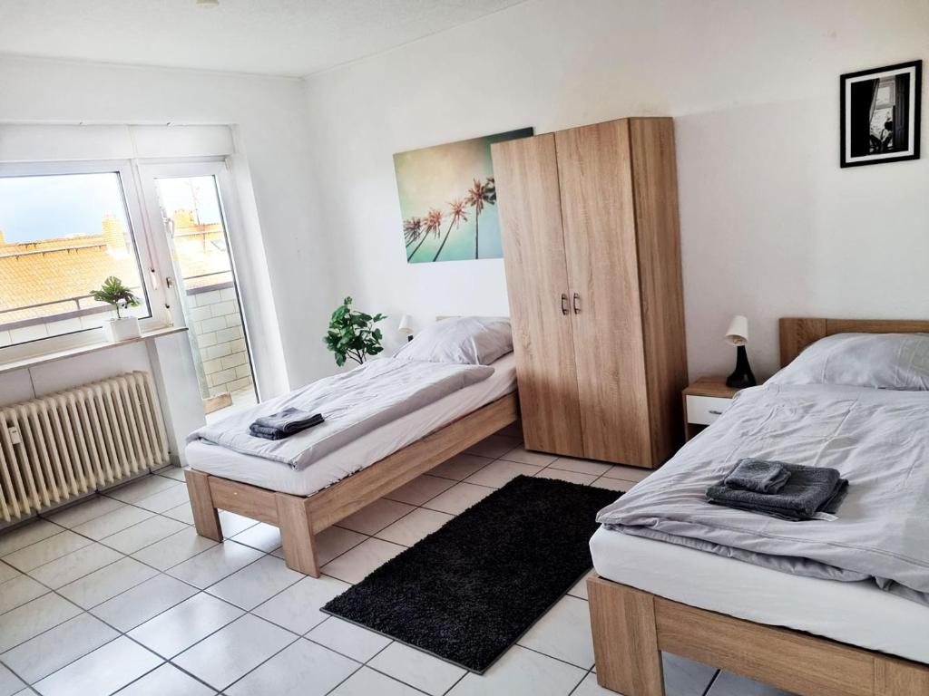 sypialnia z 2 łóżkami i oknem w obiekcie Workers Apartment in Offenbach w mieście Im Teller