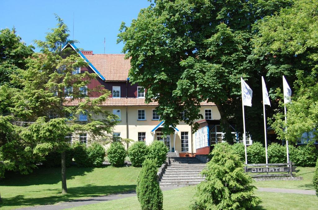 a large house with flags in front of it at Hotel Jurate in Nida