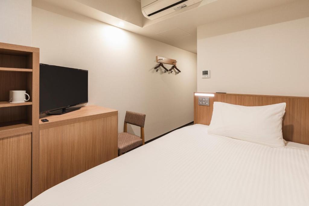 Postel nebo postele na pokoji v ubytování Sotetsu Fresa Inn Yokohama Higashiguchi