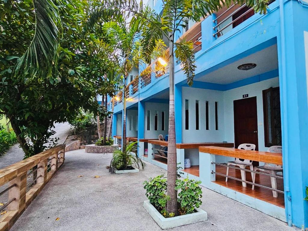 een blauw huis met een palmboom ervoor bij Ocean View Resort in Ko Tao