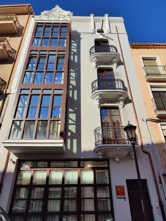 a tall white building with windows and a balcony at Costanilla Turismo in Zamora