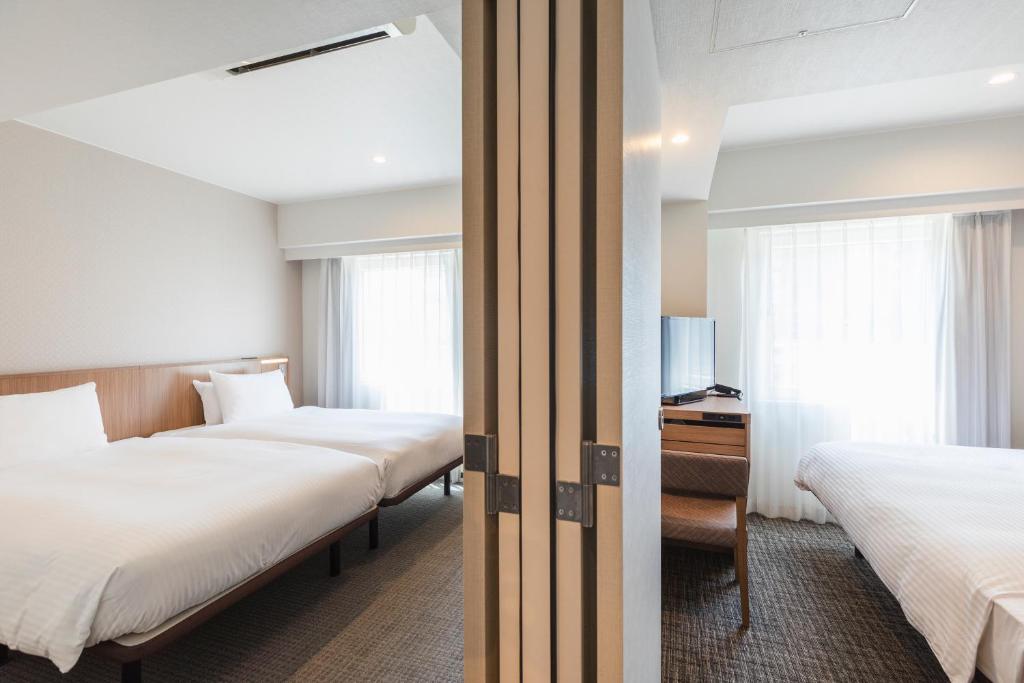 Postel nebo postele na pokoji v ubytování Sotetsu Fresa Inn Yokohama Higashiguchi