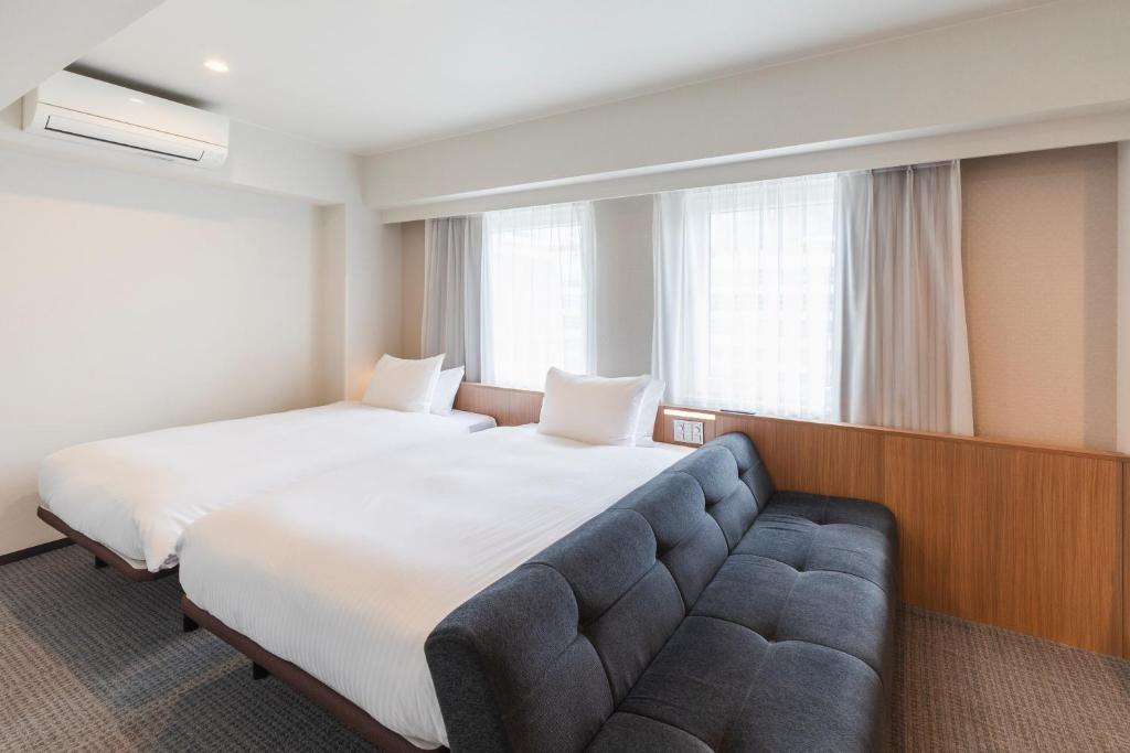 Postel nebo postele na pokoji v ubytování Sotetsu Fresa Inn Yokohama Higashiguchi