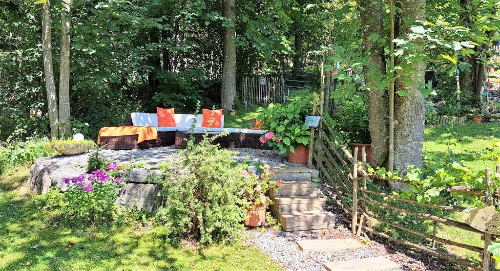 einen Garten mit einem Sofa und ein paar Blumen und einem Zaun in der Unterkunft Ferienwohnung Lechner in Abtenau