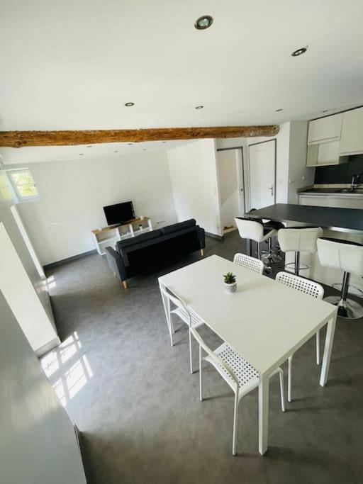 un salon avec une table et des chaises blanches dans l'établissement Chez Léo III, à Bollène