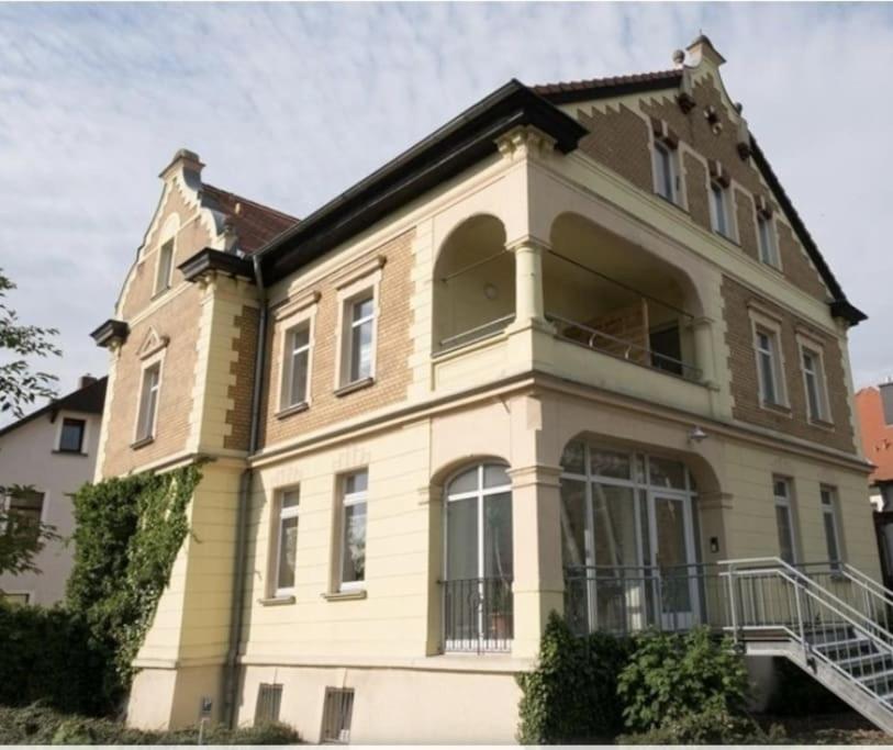 Casa amarilla grande con ventana grande en Ferienwohnung direkt am Kurpark Laga mit Gradierwerk Solestadt, en Bad Dürrenberg