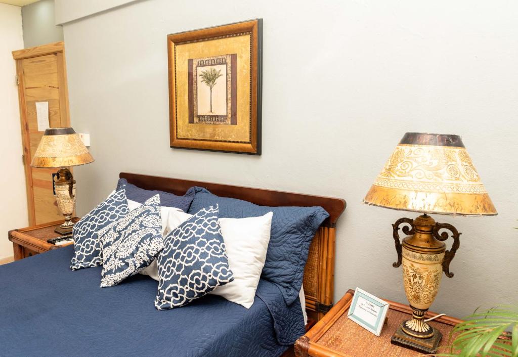 um quarto com uma cama azul com almofadas e um candeeiro em Hotel Boutique Simona em La Romana