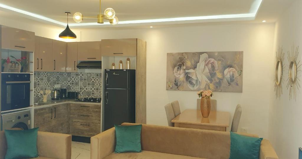 een woonkamer met een bank en een keuken bij Cosy House La Marsa in La Marsa