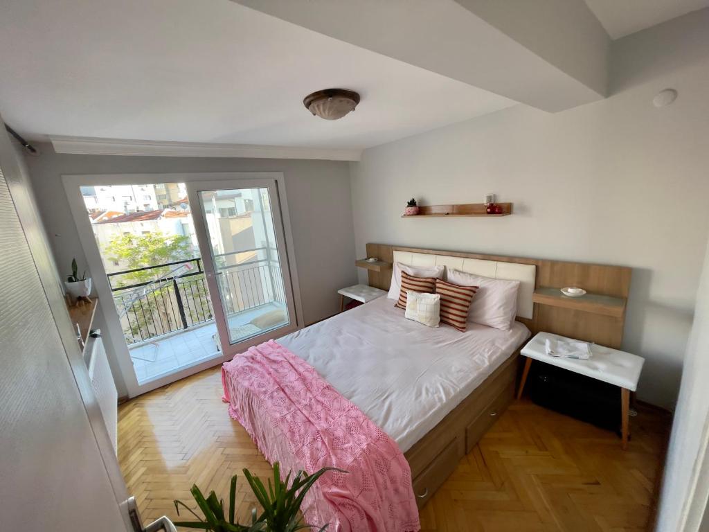 een slaapkamer met een groot bed en een raam bij Central Izmir Delight: Cozy Alsancak Apartment in Konak