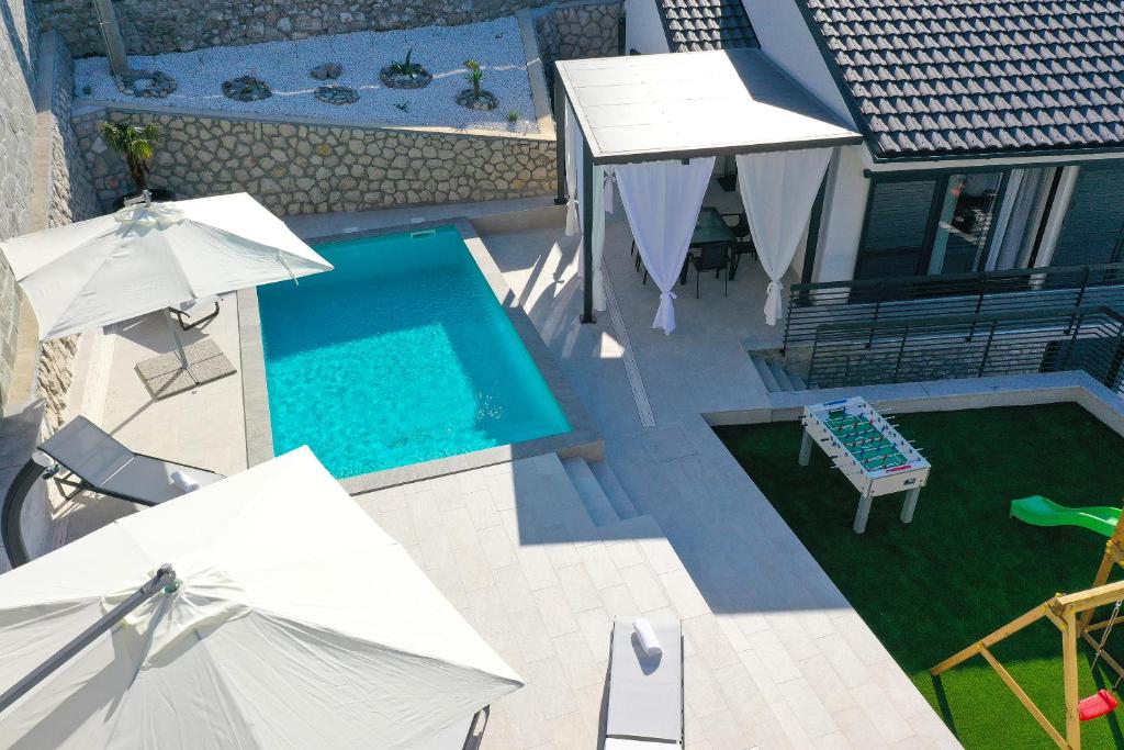 een uitzicht over een zwembad met parasols bij Villa Rene in Jadranovo