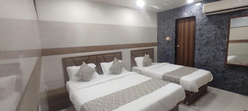 twee bedden in een hotelkamer met bij Hotel Royal Sky in Ahmedabad