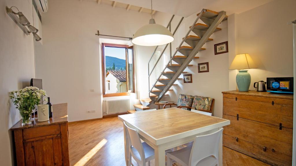 ein Wohnzimmer mit einem Tisch und ein paar Treppen in der Unterkunft Appartamento nel verde a Firenze in Settignano