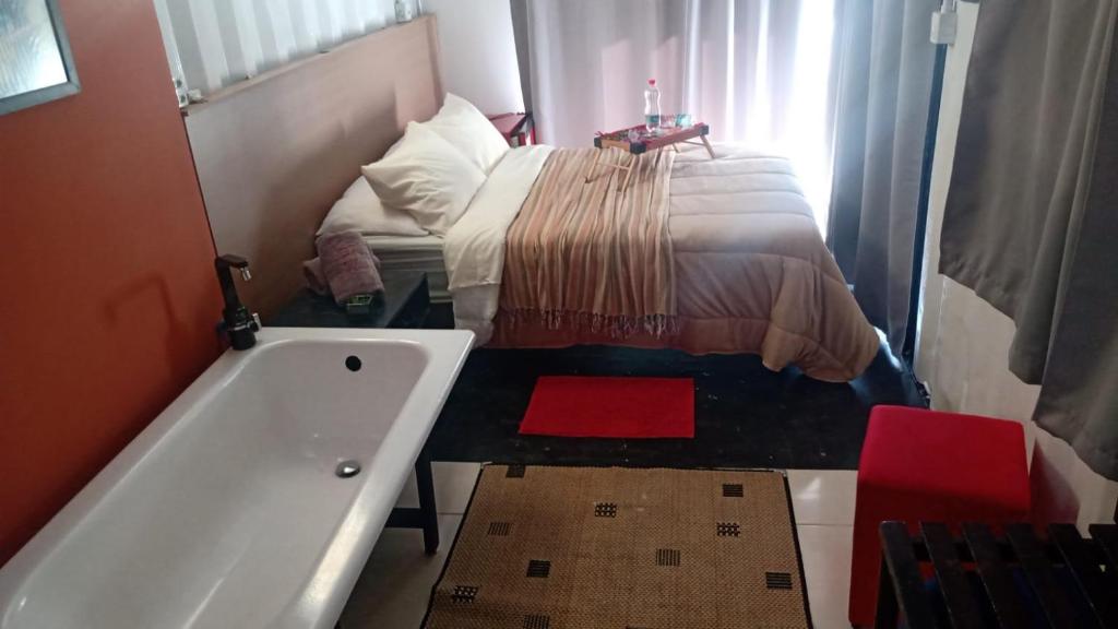 a small bathroom with a bed and a bath tub at Ecaffe Hotel Pousada Container - Coqueiral MG in Coqueiral