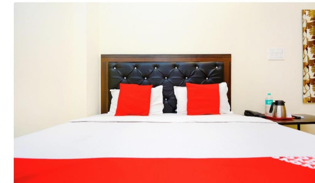 a bedroom with a large bed with red pillows at Hotel Golden Height in Chandīgarh