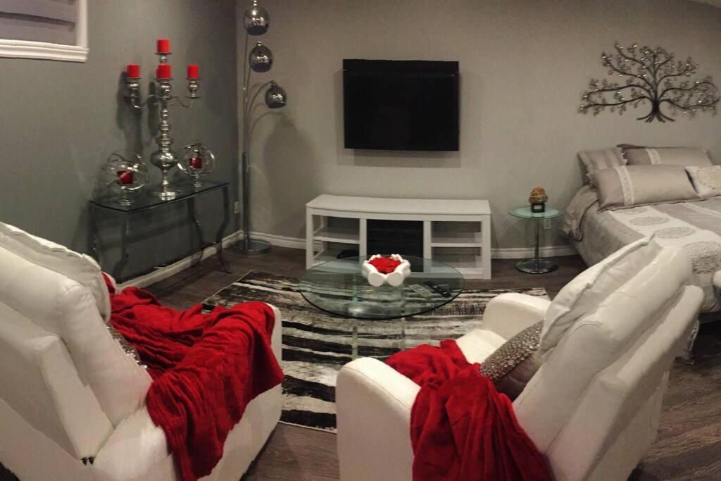 sala de estar con 2 sofás blancos y TV en Loft Nid d’amour, en Quebec