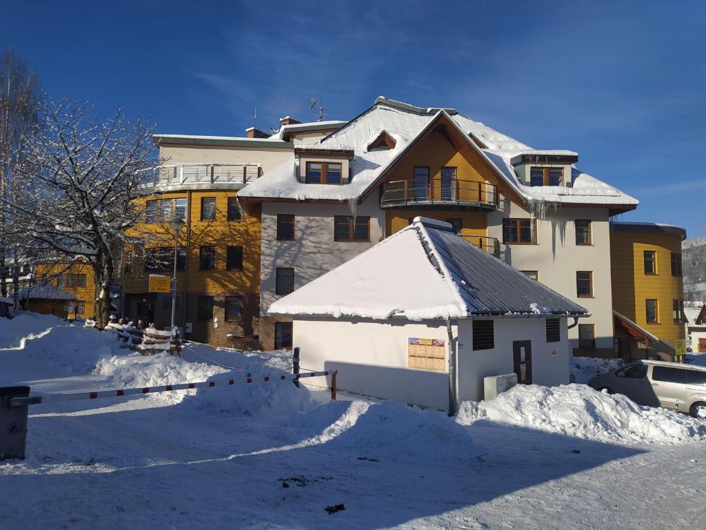 un gran edificio con nieve en el suelo en Apartment Klara en Rokytnice nad Jizerou