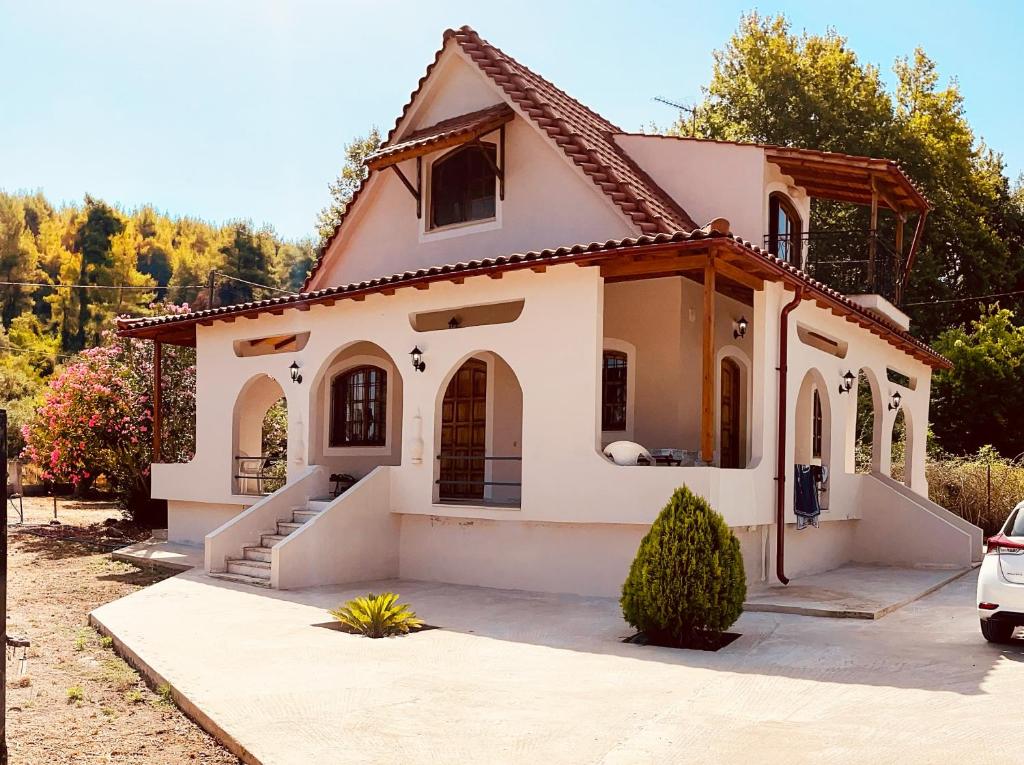 a small white house with a roof at Cheerful artist villa in the genuine part of Evia Greece in Kastríon