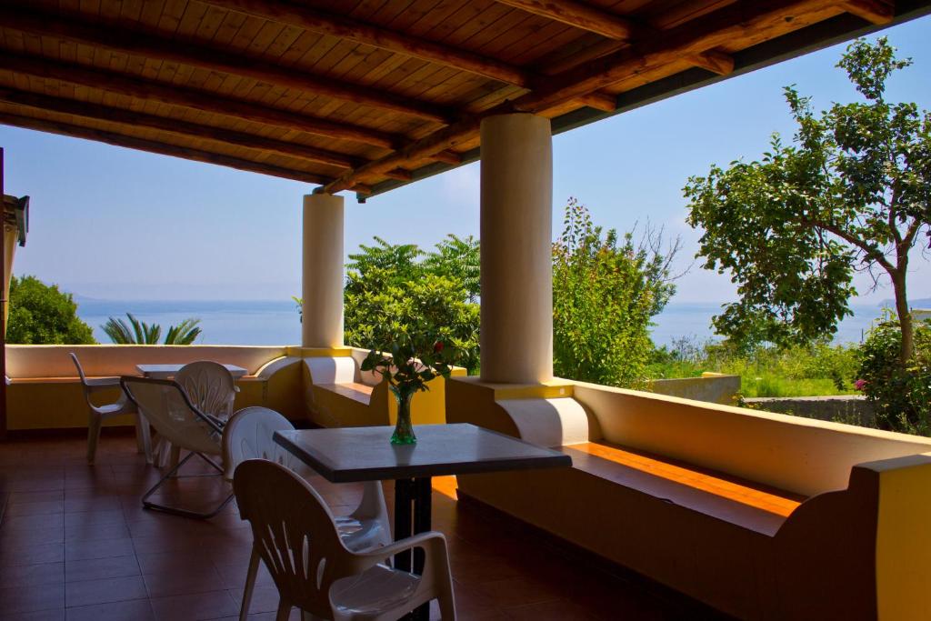 a patio with a table and chairs and a view of the ocean at Case Tita - Salina in Santa Marina Salina