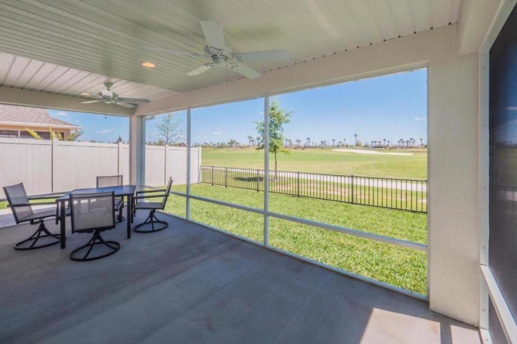 un patio con mesa y sillas y vistas a un campo en Golf Course View In Cason Hammock, en The Villages