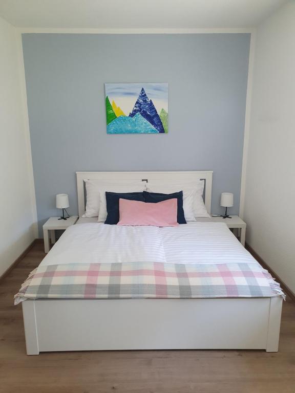 1 dormitorio con cama blanca y manta a cuadros en Brunnalm Ski - Ferien Apartment - Veitsch - max 6 Person en Niederaigen