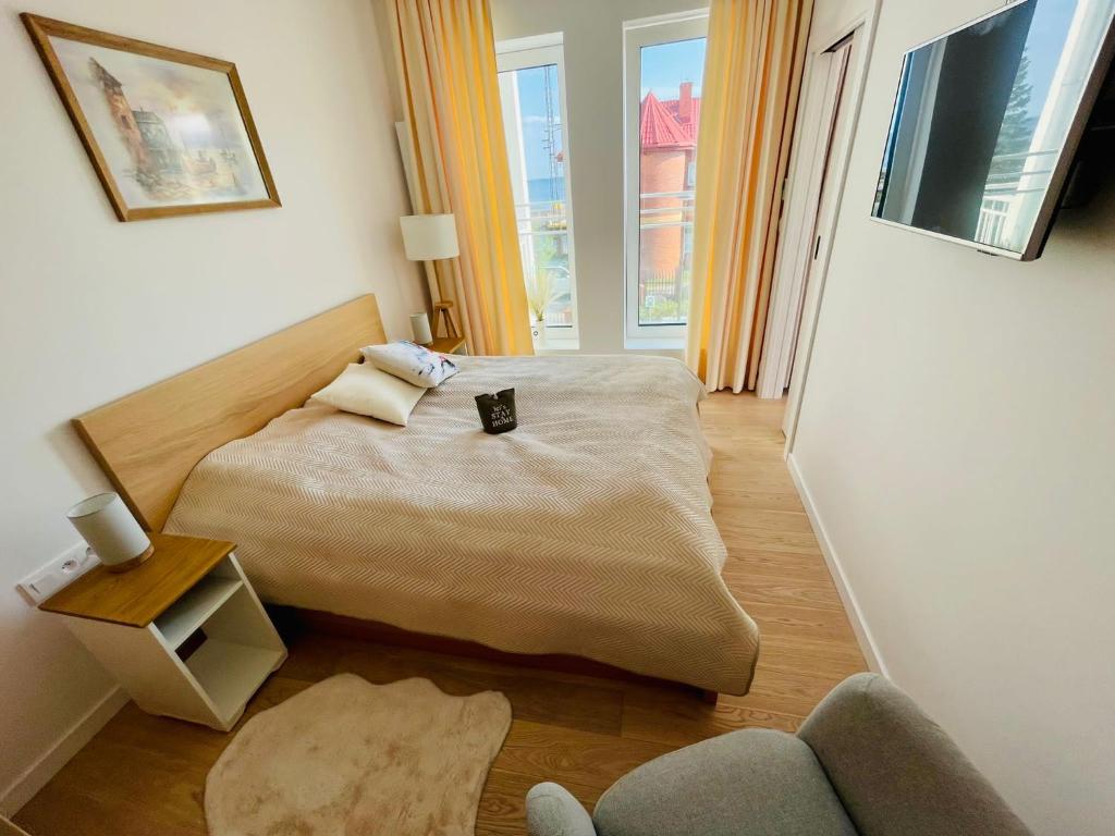 a bedroom with a bed and a couch and a window at Apartament Marina View in Darłowo