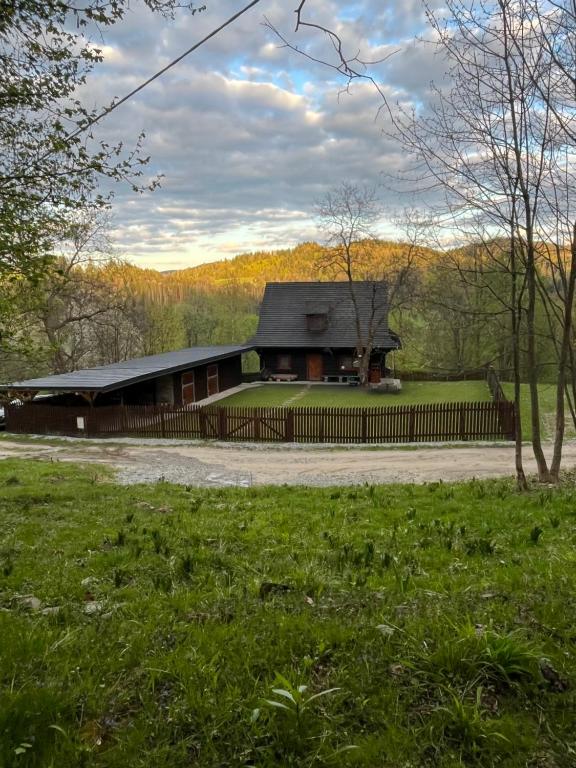 uma casa com uma cerca em frente a um campo em Chalupa u Golisov em Zákopčie