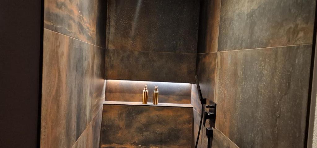 a bathroom with a metal wall with two faucets at Privat-Spa mit Whirlpool und Sauna in Sursee in Sursee