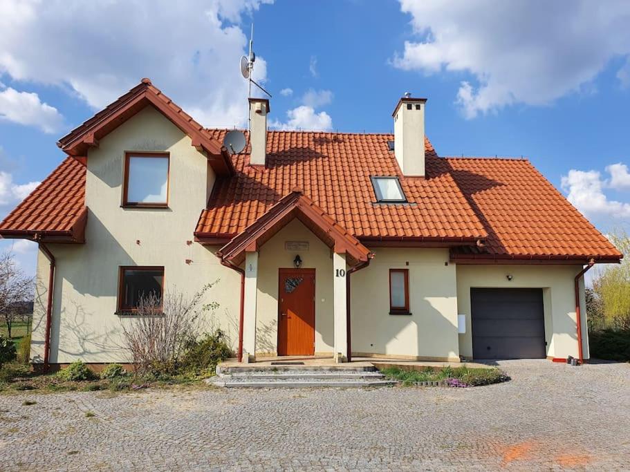 une maison blanche avec un toit rouge dans l'établissement Ducka Wola 10 - Cichy Zakątek, sielanka na wsi, à Stromiec
