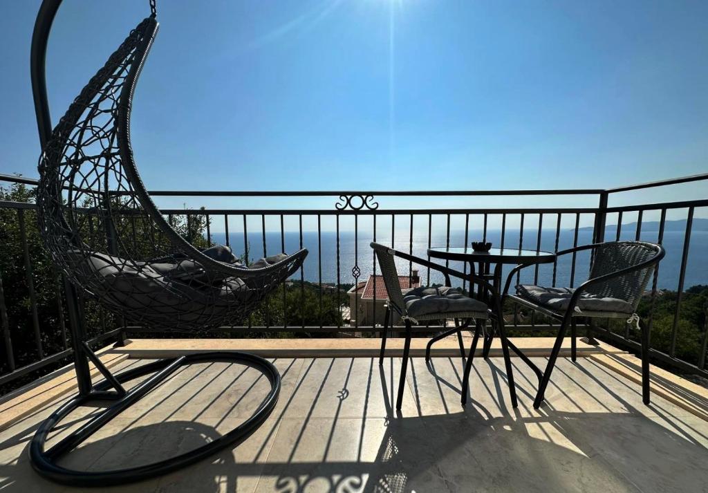 a balcony with a hammock and a table and chairs at Almond Apartments in Sveti Stefan