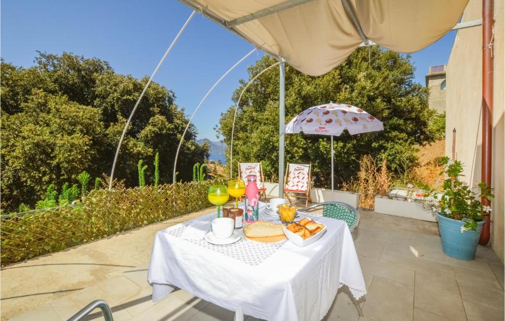 una mesa con comida y bebida y una sombrilla en Beautiful Apartment In Piana With House A Mountain View, en Piana