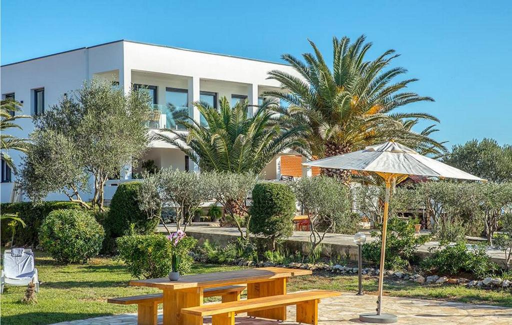 a picnic table with an umbrella in front of a building at Villa Sunset Loft in Vir