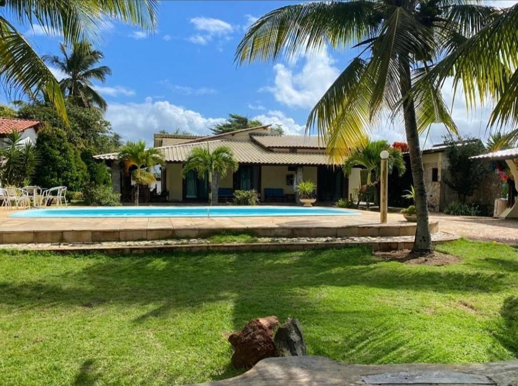 uma casa com piscina e palmeiras em Casa LUXO Guaibim em Guaibim
