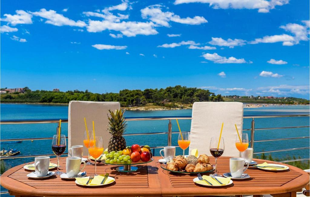 a table with food and drinks and a view of the water at Villa Am 2 in Nin