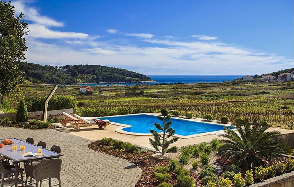 a patio with a pool and a table and a view of the ocean at Villa Mar in Lumbarda