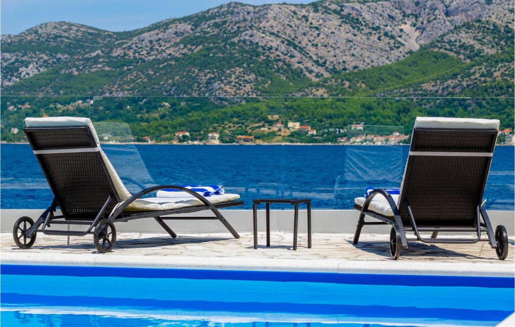 two chairs and a table next to a swimming pool at Villa Gabriela Korcula in Korčula