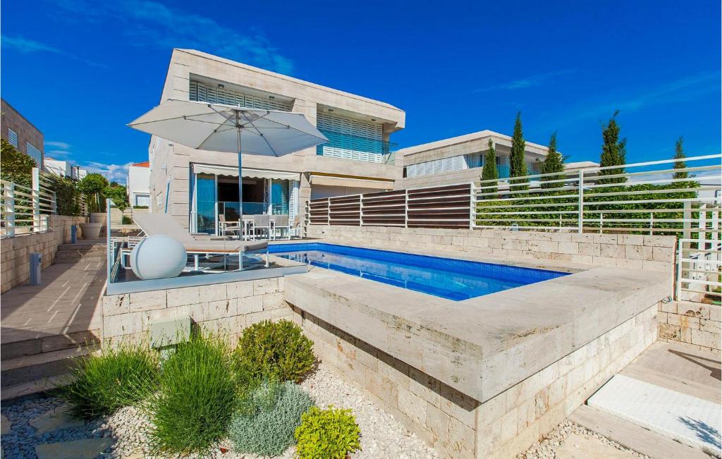a house with a swimming pool and an umbrella at Villa Lantana in Petrcane