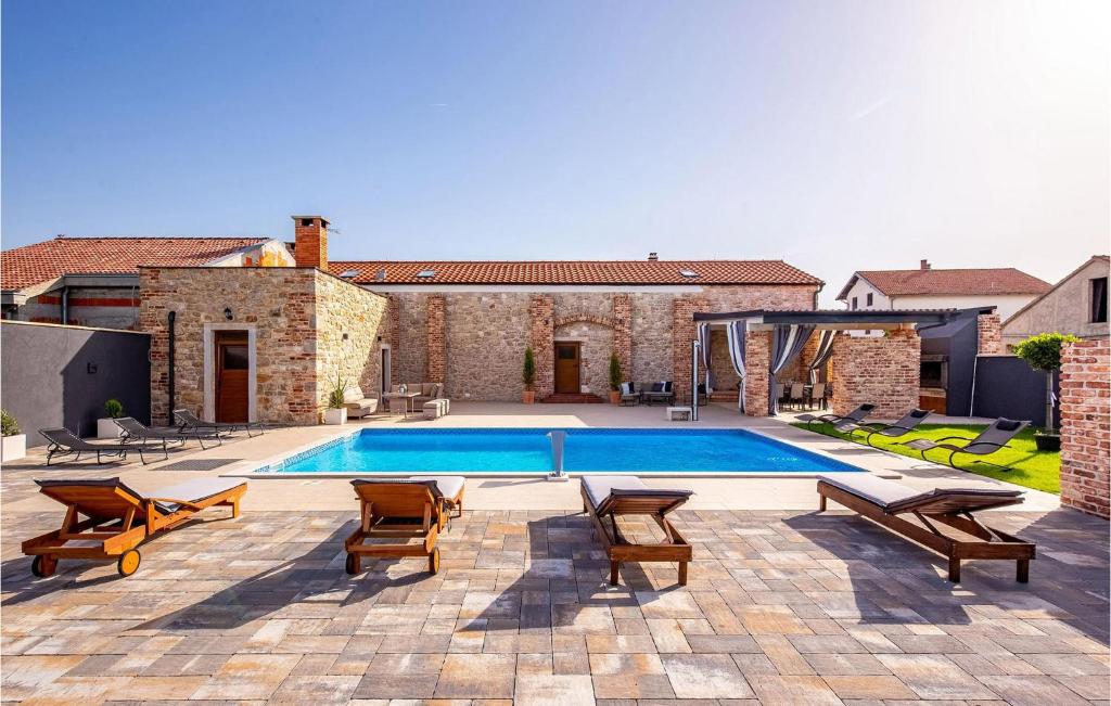 - une piscine avec 2 chaises et une terrasse dans l'établissement Villa Ambar, à Škabrnje