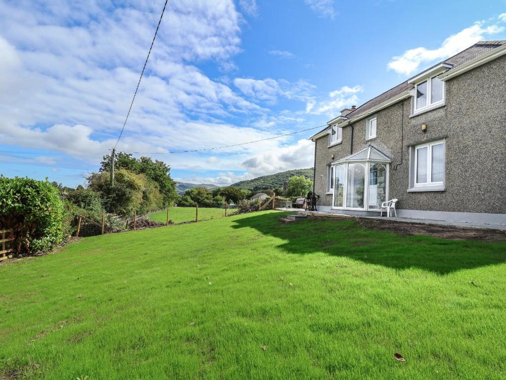 a house with a large lawn in front of it at Ffriddoedd in Llanfairfechan