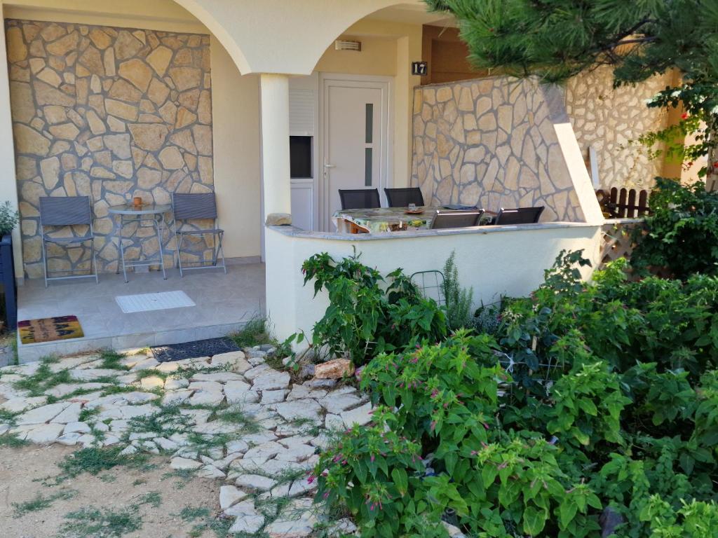 a house with a stone wall and a patio at Apartman Stela in Nin