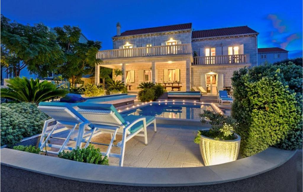 a house with a swimming pool and chairs in front of it at Villa Veritas in Lumbarda