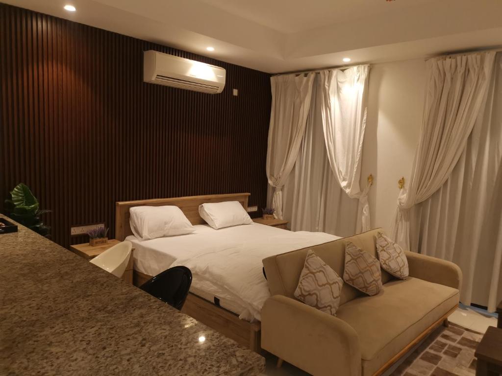 1 dormitorio con 1 cama y 1 sofá en هوانا صلاله en Ma‘mūrah
