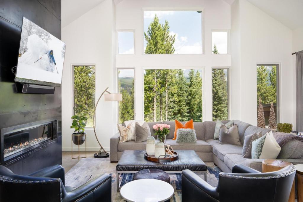 a living room with a couch and chairs and a fireplace at Gray Owl Retreat in Big Sky