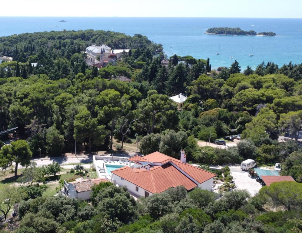 une vue aérienne sur une maison avec des arbres et l'eau dans l'établissement Villa Salteria 3, pool, private territory, pinery, à Rovinj