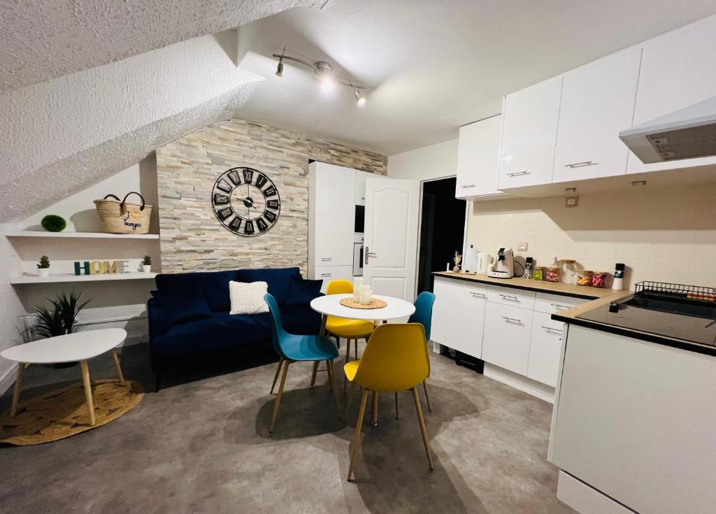 uma cozinha e uma sala de estar com mesa e cadeiras em Appartement « My love » em Sainte-Savine
