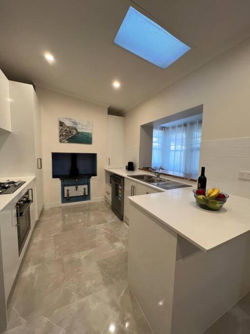 a kitchen with a sink and a counter top at Close to CBD Renovated Cottage in Prospect