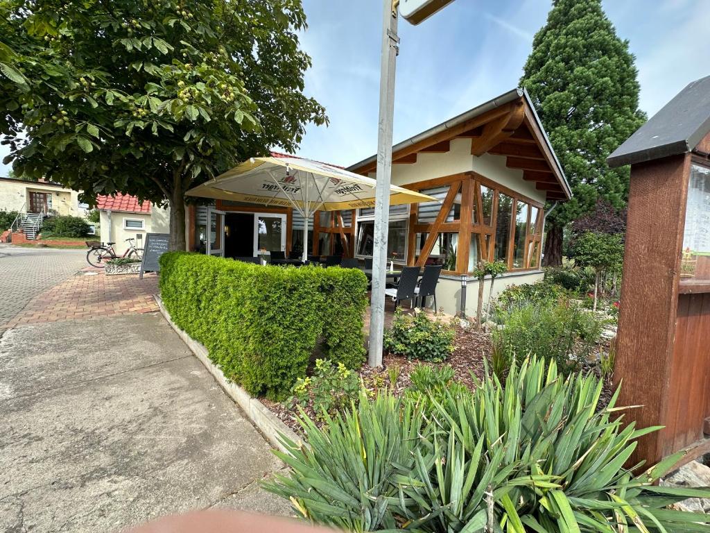 un restaurant avec un bâtiment doté d'une terrasse couverte dans l'établissement Gasthaus Am Colphus, à Barby