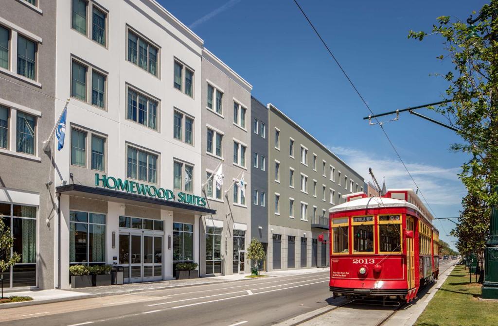 a red trolley on a street in front of a building at Homewood Suites By Hilton New Orleans French Quarter in New Orleans